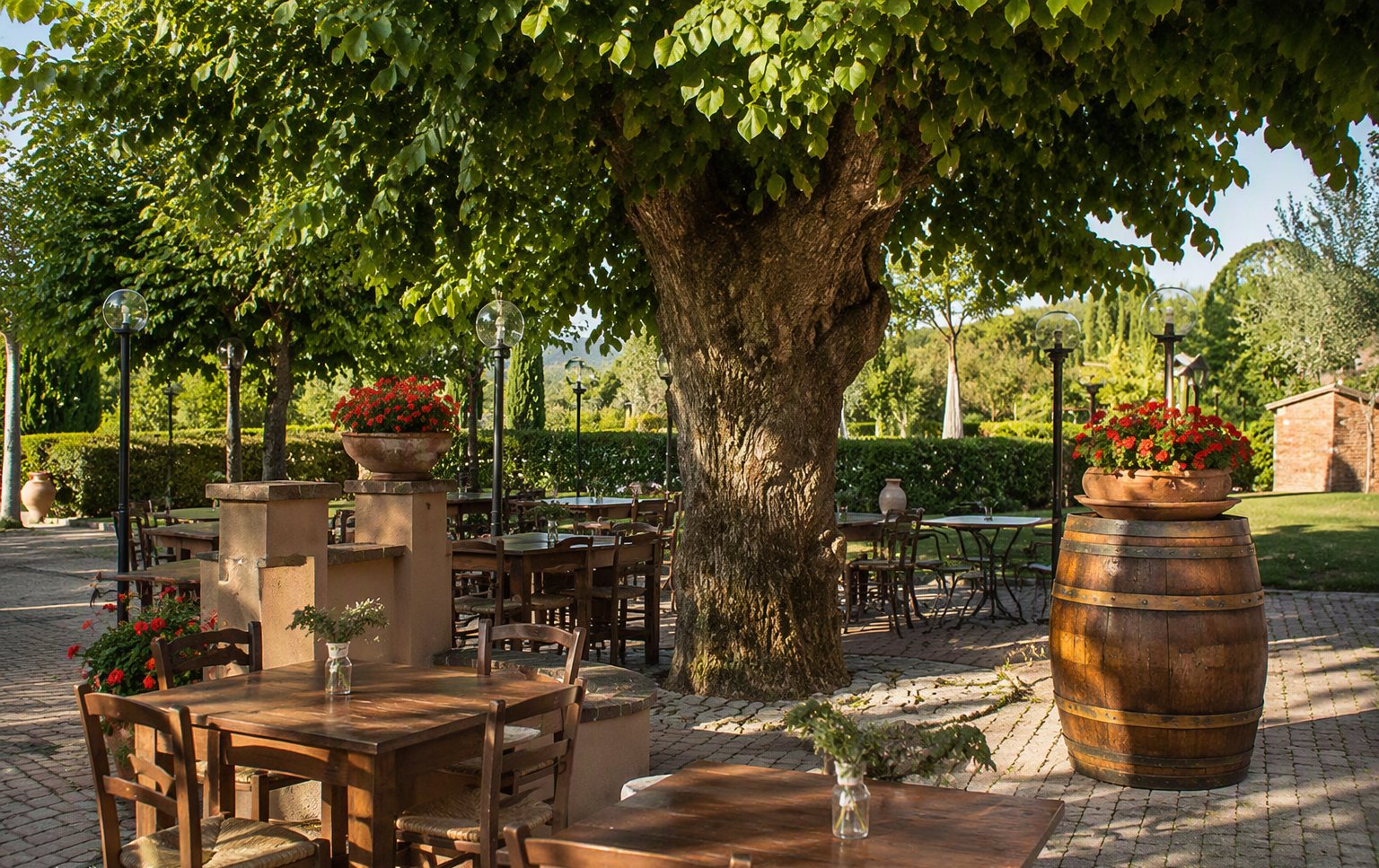 I tavoli all'aperto nel giardino, tra le botti e il verde